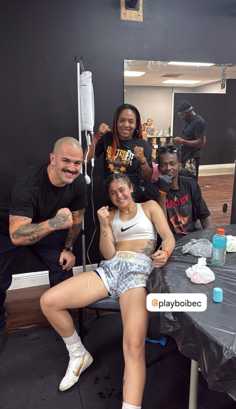 A fighter receiving IV hydration with her team after training
