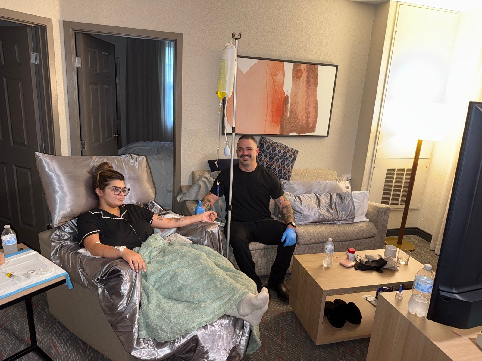 Javier checking on a client during an IV hydration visit in a recovery suite